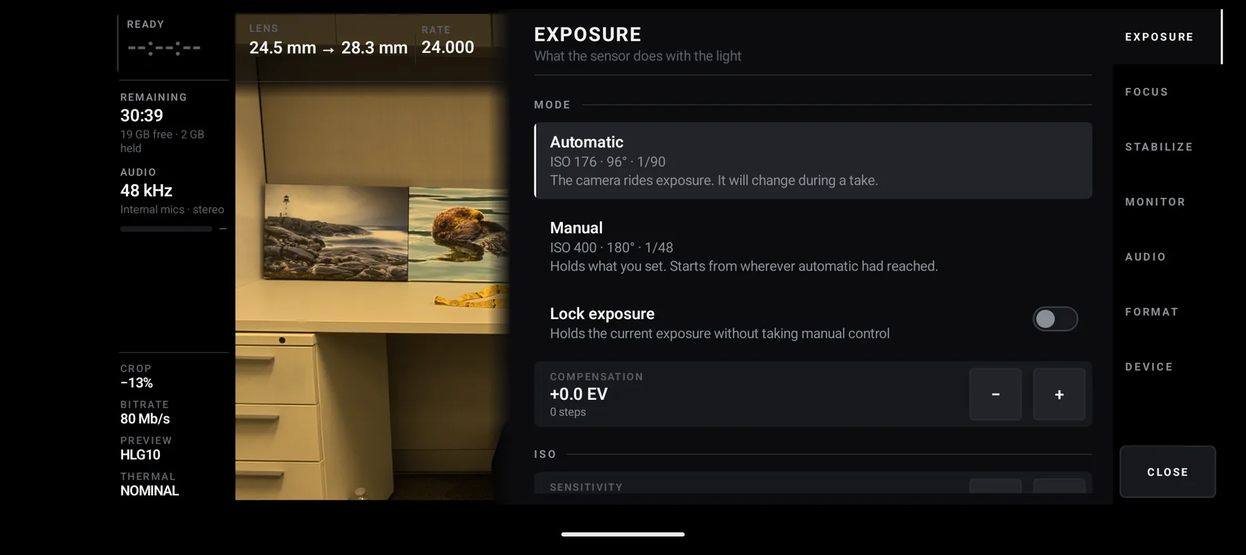 The exposure panel: Automatic, reading ISO 155, 96 degrees, 1 over 90, described as
                  ‘The camera rides exposure. It will change during a take.’; Manual below it; a lock
                  toggle; and exposure compensation at plus zero EV.